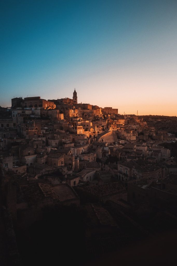 A view of a city at sunset from the top of a hill