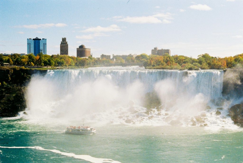 a large waterfall with a boat in the water