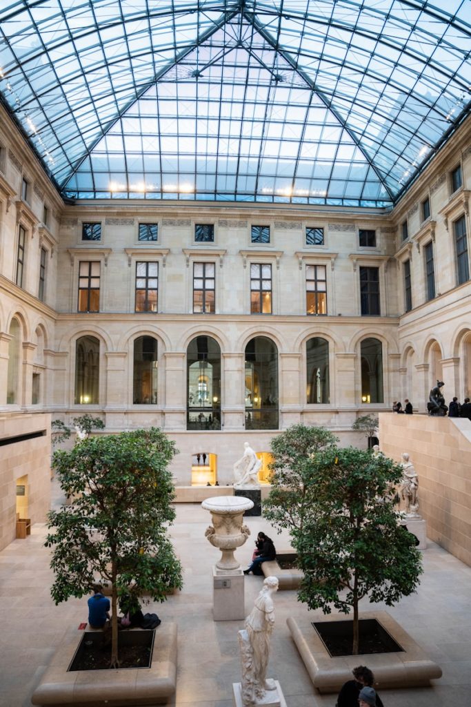 a large building with a glass roof and a fountain in the middle of it