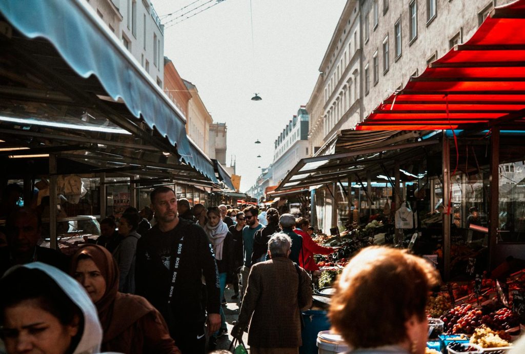 Explore the vibrant stalls and diverse crowds of Vienna's famous Naschmarkt, a must-visit for travelers.