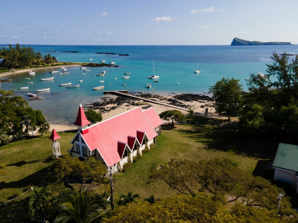 an aerial view of a small church on the shore