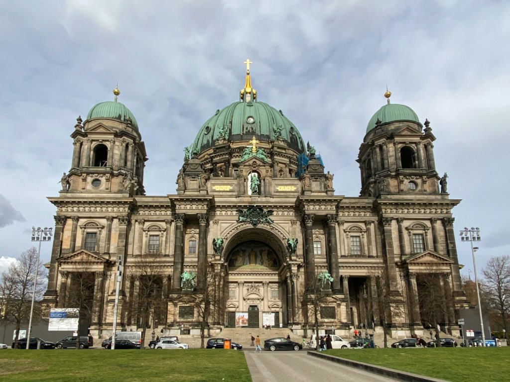 Berlin cathedral stands tall under a cloudy sky.