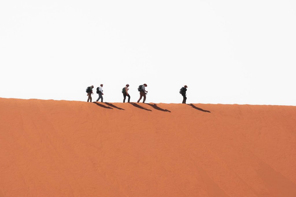 a group of people walking on sand